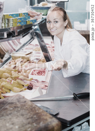 Woman showing product in delicatessen section Woman showing product in delicatessen section 36730452