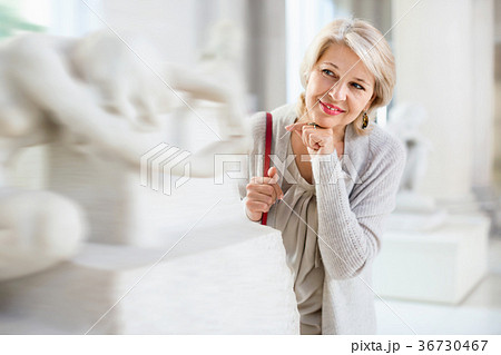 Adult female looking at artwork sculpture in the museum indoors 36730467