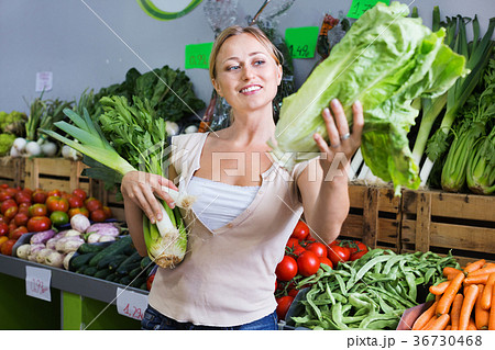 Portrait of woman shopping fresh green celery, leek and lettuce 36730468