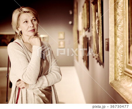 Mature woman in art museum near the painting 36730477