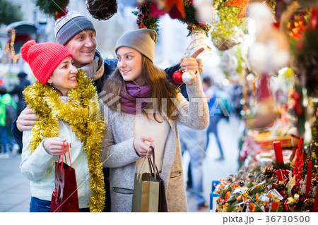 middle-aged married couple with a teenage daughter at Christmas market 36730500