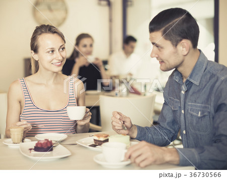 attractive woman with boyfriend meeting and drinking coffee with pastry at cafe attractive woman with boyfriend meeting and drinking coffee with pastry at cafe 36730566