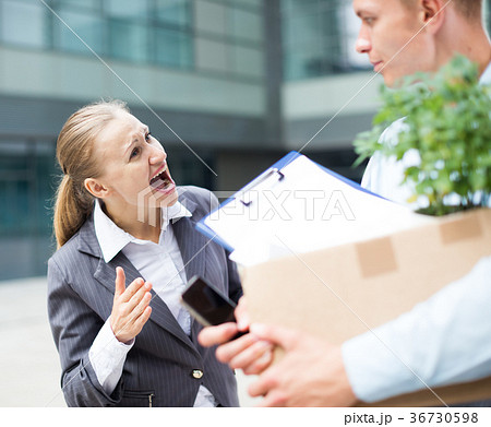 Irate woman is dismissing young manager for violating the job description Irate woman is dismissing young manager for violating the job description 36730598