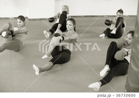 Group of women in gloves are exercise moves sitting Group of women in gloves are exercise moves sitting 36730600