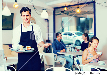 Male waiter is warmly welcoming guests 36730782
