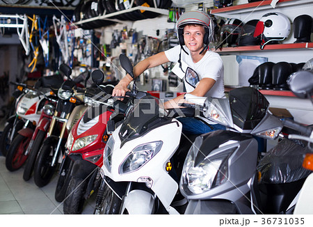 Portrait of glad male in helmet on motorbike in the store 36731035