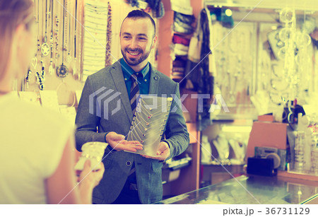 Cheerful male offering to buy fashionable necklace Cheerful male offering to buy fashionable necklace 36731129