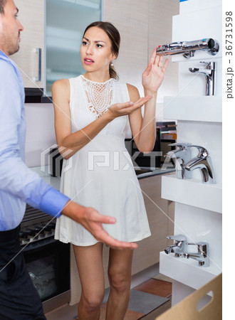 Dissatisfied female client showing discontent to seller 36731598
