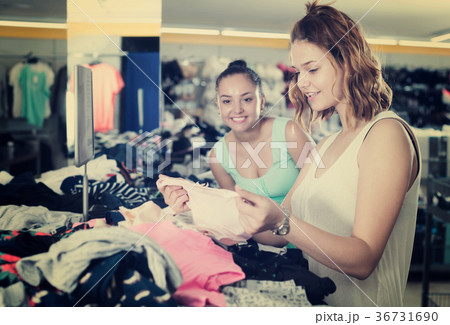 Young women friends selecting new basics pants 36731690