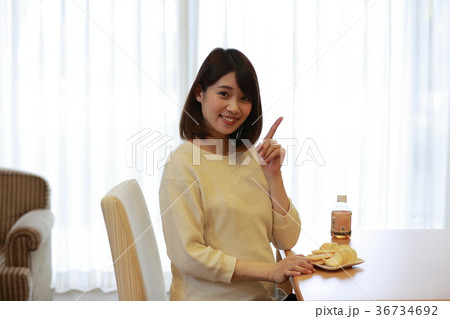 お菓子を前に指差しポーズするマタニティ女性 36734692