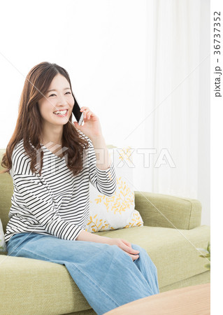 ソファーでスマホを使う女性　 36737352