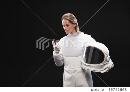Trained woman cosmonaut is using smartphone 36741668