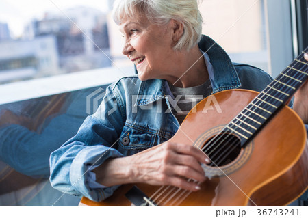 Elegant old lady holding musical instrument while Elegant old lady holding musical instrument while 36743241