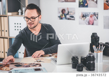 Cheerful bearded man looking at photos Cheerful bearded man looking at photos 36743572