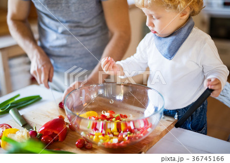 Young father with a toddler boy cooking. Young father with a toddler boy cooking. 36745166