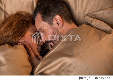 Cute loving couple relaxing at bedtime Cute loving couple relaxing at bedtime 36745172
