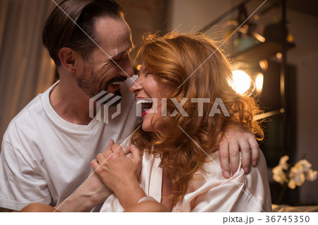 Joyful man and woman laughing in bedroom 36745350