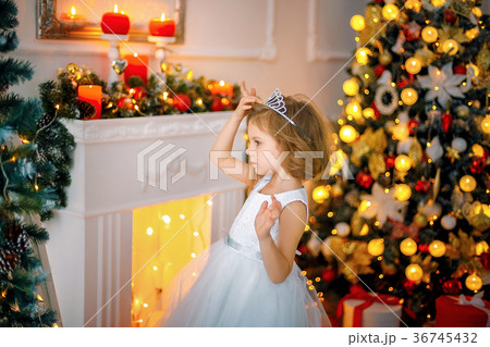 Little girl posing in a dress near the mirror Little girl posing in a dress near the mirror 36745432