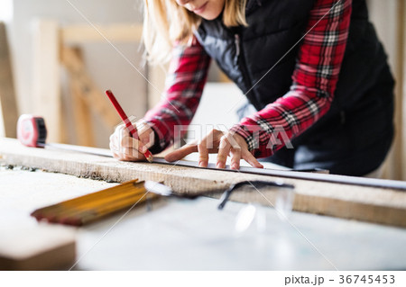 Young woman worker in the carpenter workroom. Young woman worker in the carpenter workroom. 36745453