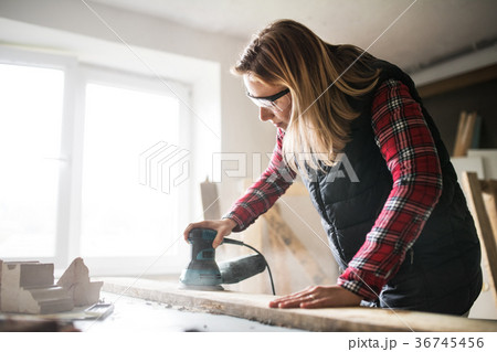 Young woman worker in the carpenter workroom. Young woman worker in the carpenter workroom. 36745456