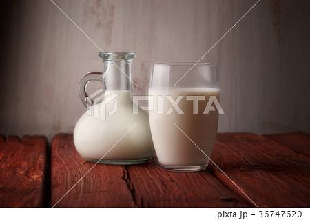 Fresh milk in glass jug and glass on wooden Fresh milk in glass jug and glass on wooden 36747620