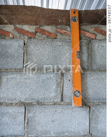 Old level ruler is hanging on the brick wall. Old level ruler is hanging on the brick wall. 36748537