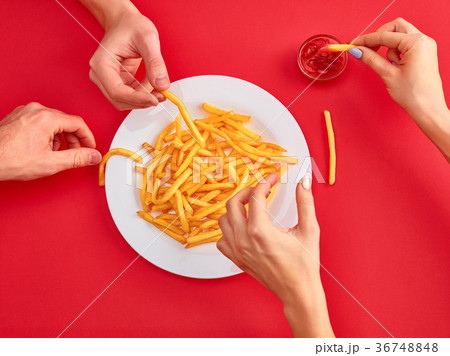 Young woman eating french fries potato with Young woman eating french fries potato with 36748848
