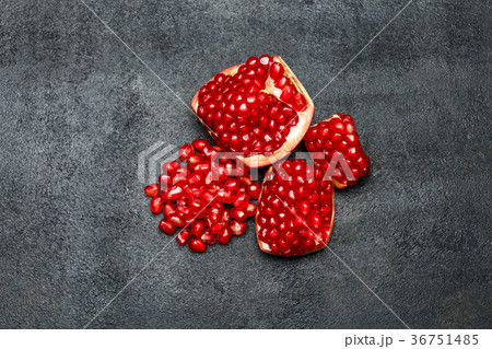 Pomegranate and seeds close-up on dark concrete 36751485