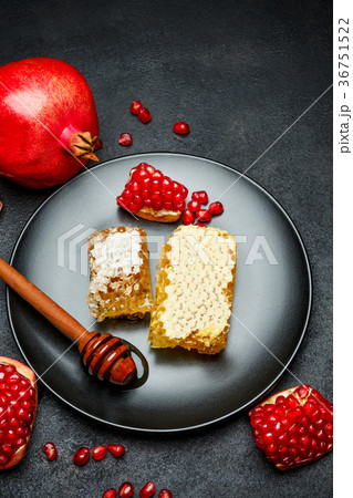 Pomegranate and honeycomb close-up on dark 36751522