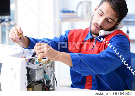 Young repairman fixing and repairing microwave 36764036