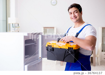 Repairman contractor repairing fridge in DIY 36764137