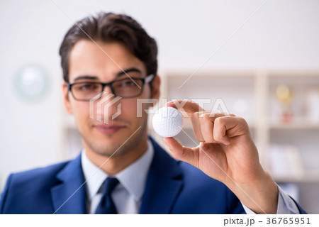 Young businessman with golf ball working in office 36765951