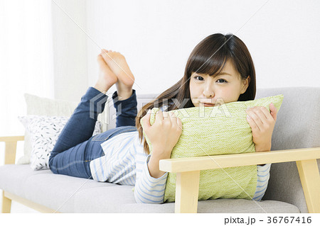 ソファでリラックスする若い女性 の写真素材