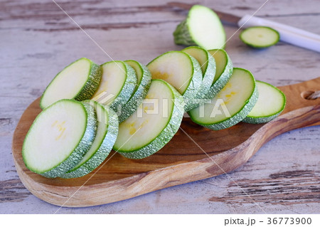 Fresh cut zucchini on a wooden cutting board. 36773900