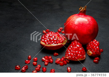 Pomegranate and seeds close-up on dark concrete 36774550