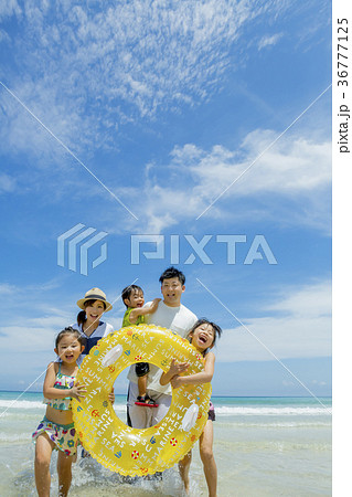 夏の海辺で浮輪を持って遊ぶ5人家族 36777125