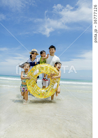 夏の海辺で浮輪を持って遊ぶ5人家族 36777126