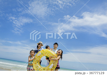 夏の海辺で浮輪を持って遊ぶ5人家族 36777129