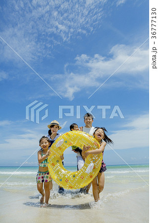 夏の海辺で浮輪を持って遊ぶ5人家族 36777130