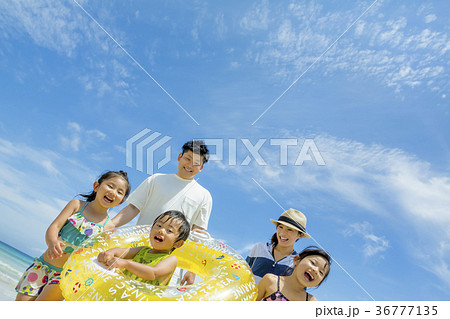 夏の海辺で浮輪を持って遊ぶ5人家族 夏の海辺で浮輪を持って遊ぶ5人家族 36777135