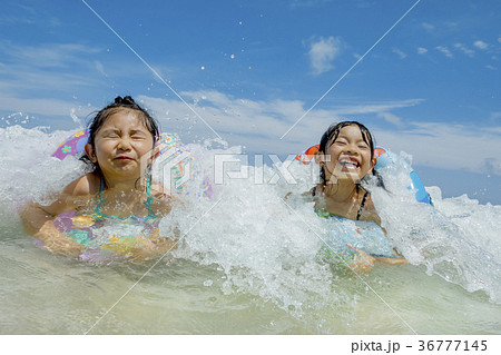 夏の海辺で遊ぶ姉妹 36777145