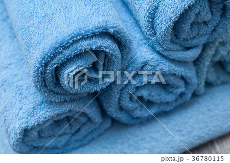 blue rolled bath towels on wooden table blue rolled bath towels on wooden table 36780115