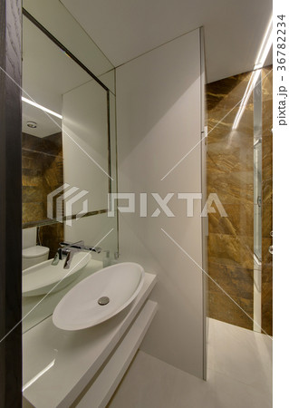 A white bathroom with a white sink and a big mirro A white bathroom with a white sink and a big mirro 36782234
