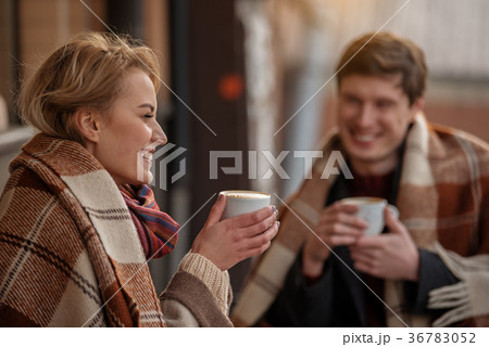 Smiling couple dating outdoors with hot beverage 36783052