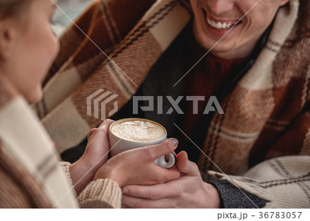 Sweet young couple holding cup of hot drink 36783057