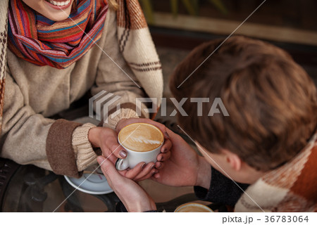 Lovely young couple keeping together cup of hot Lovely young couple keeping together cup of hot 36783064