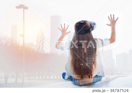 Girl in VR headset sits with her back to camera 36787526