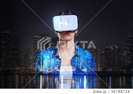 Young woman in VR headset posing against night 36788738