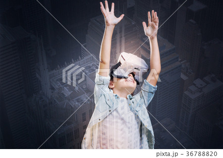 Happy girl in VR headset raising her hands up Happy girl in VR headset raising her hands up 36788820