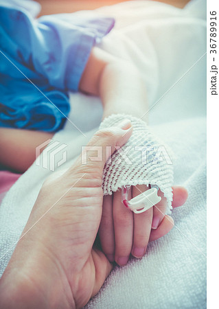 Parent holding child's hand for encouragement. 36789916